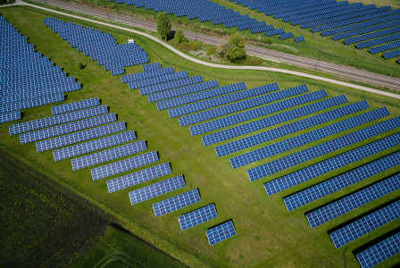 Photo by Unsplash An illustrative photo of grass field with blue solar panels