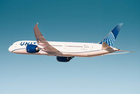 An illustrative photo of a white and blue passenger plane in flight