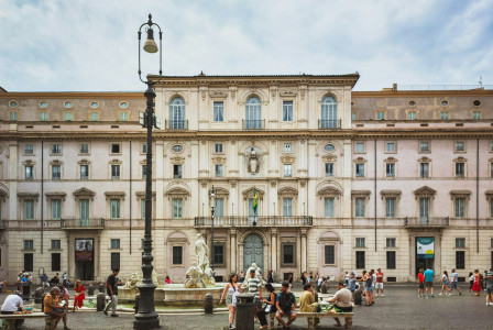 An illustrative photo of a group of people sitting around a fountain in front of a building