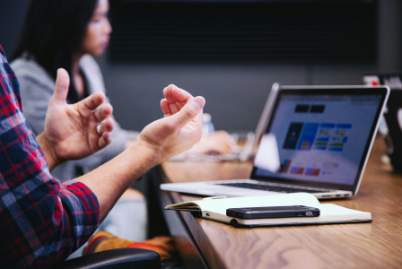 An illustrative photo of a person sitting at a table, likely during a meeting or work session.