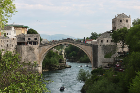 An illustrative photo of a bridge over a river with a boat on it.