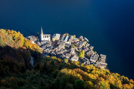 An illustrative photo of  an aerial view of a densely built town with traditional architecture, nestled on the edge of a body of water