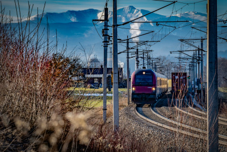 An illustrative photo of a train with mountains in the background.