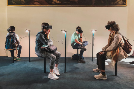 An illustrative photo of four people playing virtual reality goggles.