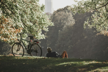 An illustrative photo of a man sitting on green grass field.