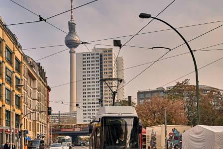 An illustrative photo of a yellow tram on a city street with overhead cables