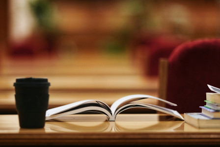 An illustrative photo of an opened book on a wooden brown table