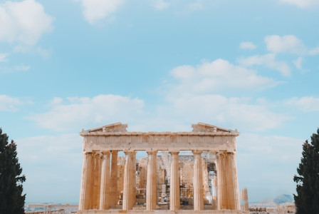 A historic brown concrete building standing tall under a clear blue sky