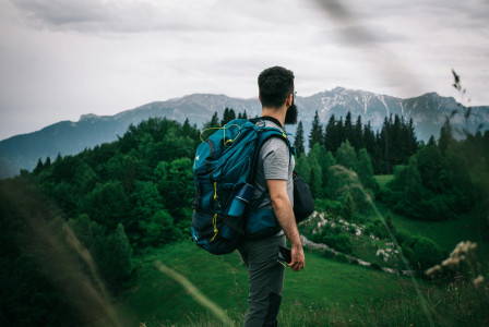 Photo by Pexels An illustrative photo of a man carrying his backpack overlooking the landscape.