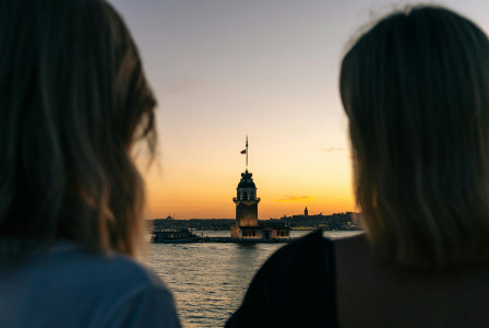 An illustrative photo of two people looking out over a body of water.
