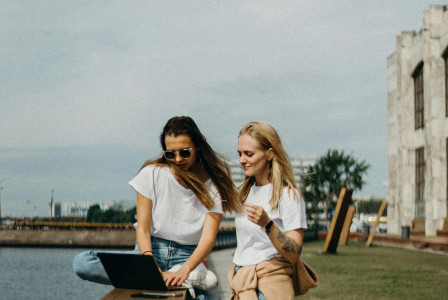 Photo by Pexels An illustrative photo of two women sitting near beach