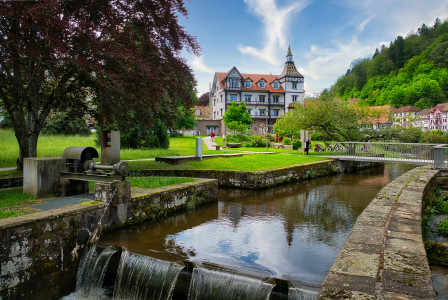 An illustrative photo of a picturesque outdoor scene featuring a small water canal with a waterfall in the foreground.