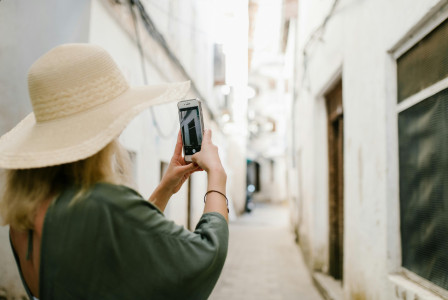 Photo by Pexels An illustrative photo of a woman taking a photo of a building in a narrow alley
