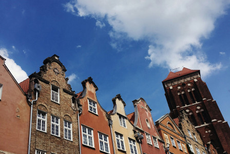 An illustrative photo of brown concrete buildings in Gdansk under blue sky during daytime