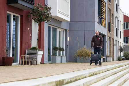 An illustrative photo of a man walking near red and gray buildings