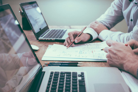 An illustrative photo of two people working together at a desk.