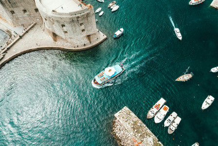 An illustrative photo of white boats in a body of water near a castle