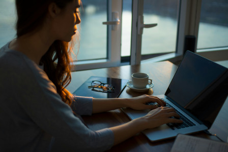 Photo by Unsplash An illustrative photo of a woman sitting beside table using laptop.