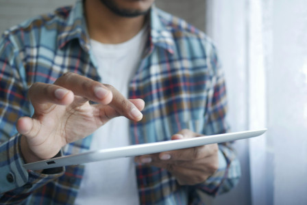 Photo by Unsplash An illustrative photo of a man holding a tablet.