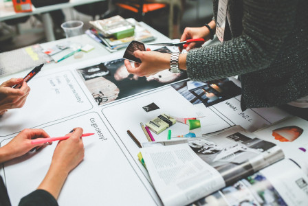 An illustrative photo of a collaborative work environment with multiple people gathered around a table.