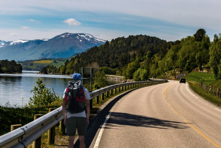 An illustrative photo of a person walking on gray concrete road.