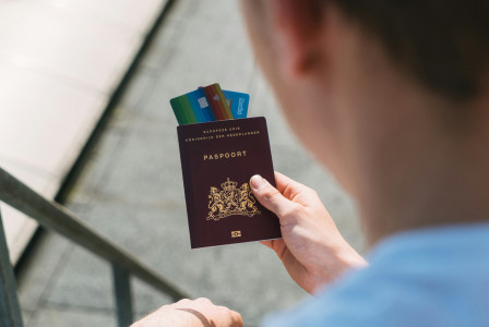 An illustrative photo of a person holding a passport.