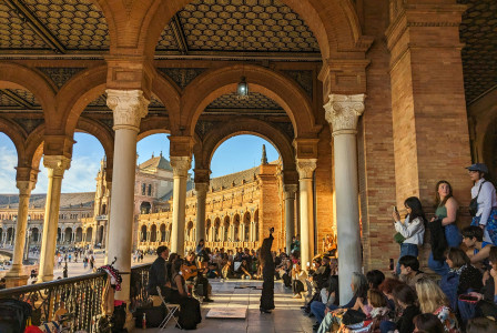 An illustrative photo of a group of people sitting and standing around a building