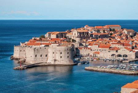 An illustrative photo of buildings with orange roofs on the coast near the sea