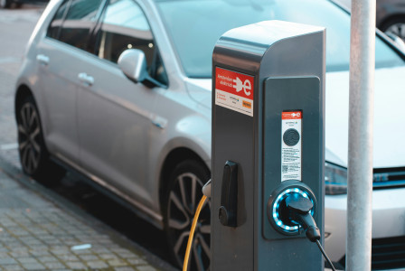 An illustrative photo of an electric car near a charging station 