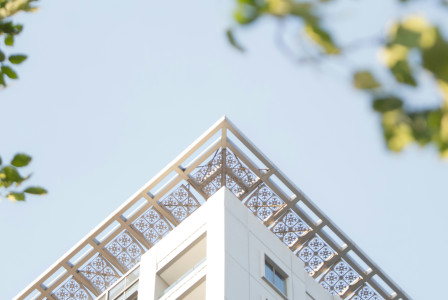 An illustrative photo of a tall building with a metal roof and a sky background