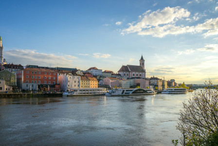 An illustrative photo of a river with boats in it near a coast with houses