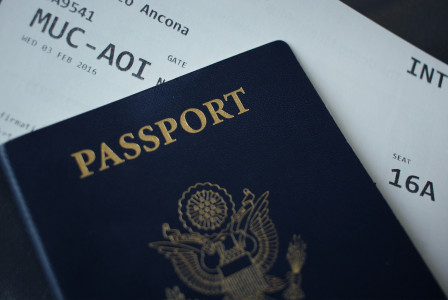 An illustrative photo of a passport on top of an airplane boarding pass