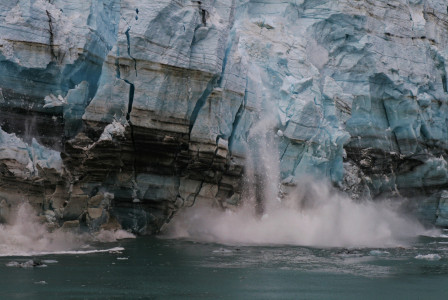 An illustrative photo of a water splash on brown rock formation during daytime