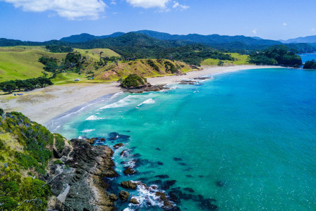 An illustrative photo of a beach with mountains in the background