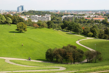 An illustrative photo of a grass field with a city in the background