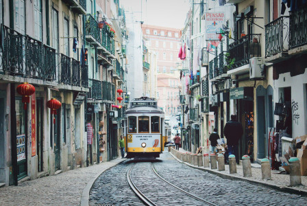An illustrative photo of a train passing in between buildings in Lisbon