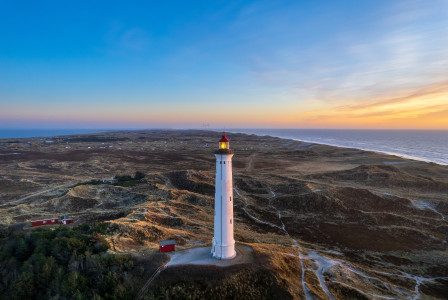 An illustrative photo of a lighthouse on a hill.