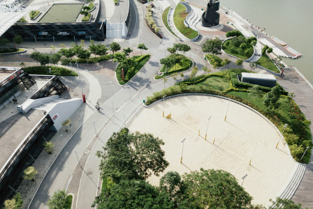 An illustrative photo of a park near road beside a body of water