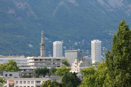 An illustrative photo of white concrete buildings near green trees
