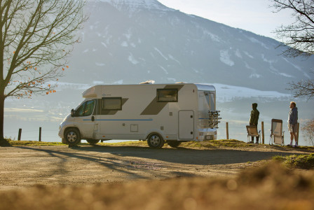 An illustrative photo of a white van parked on a road.