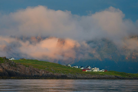 An illustrative photo of a hill with houses on top.