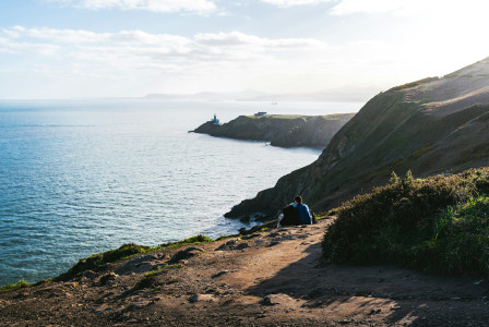 An illustrative photo of people sitting on a cliff.