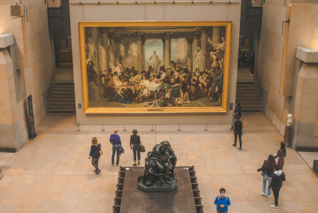 An illustrative photo of a group of people standing in front of a painting