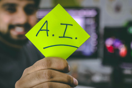 An illustrative photo of a person holding a green piece of paper.