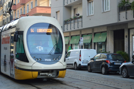 An illustrative photo of a yellow and white bus on the streets of Milan