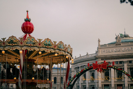 An illustrative photo of a carousel in front of a large building.