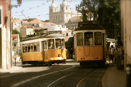 An illustrative photo of two yellow-and-white trams in Portugal