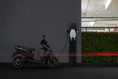 An illustrative photo of a black electric motorcycle charging 