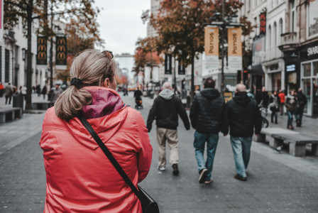 An illustrative photo of a woman walking on a street with many people