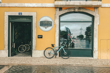 An illustrative photo of black bicycle parked beside a building.